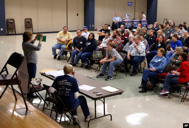 FILE - Voters listen to instructions during a Democratic party caucus in Nevada, Iowa, Feb. 1, 2016.