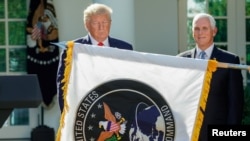 U.S. President Donald Trump stands behind a U.S. Space Command flag with Vice President Mike Pence at an event to launch the United States Space Command in Washington, Aug. 29, 2019.