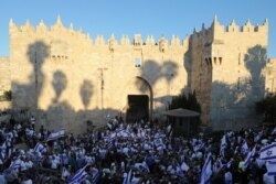 Jewish ultranationalists wave Israeli flags during the "Flags March," next to Damascus gate, outside Jerusalem's Old City, June 15, 2021.