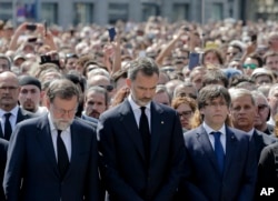 King Felipe of Spain, center, Prime Minister Mariano Rajoy, center left, and Catalonia regional President Carles Puigdemont, center right, join people gathered for a minute of silence in memory of the terrorist attacks victims in Las Ramblas, Barcelona, Spain.