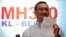 Malaysia's acting Transport Minister Hishammuddin Hussein holds up a note that he has just received on a new lead in the search for the missing Malaysia Airlines Flight MH370, during a news conference at Kuala Lumpur International Airport, Mar. 22, 2014. 