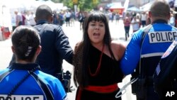 Police in Santa Fe, N.M., lead away protest organizer Jennifer Marley of San Ildefonso Pueblo in hand restraints, Sept. 8, 2017. Police say they arrested at least 12 people to contain protest against an annual pageant marking the return of Spanish conquistador Don Diego de Vargas to New Mexico following a 17th century Indian revolt.