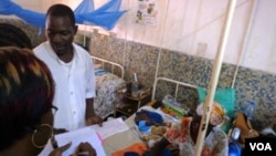 FILE - In Garoua, Cameroon, two nurses are seen attending to a patient at the local regional hospital. (VOA/D.Ntaryike). Cameroon has strongly denied that the death of a pregnant woman and her two unborn babies in a government hospital was due to negligence from the staff, which refused to grant her medical attention for not being able to pay consultation fees.