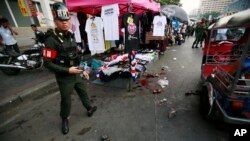 Seorang polisiberdiri di dekat lokasi ledakan di pusat lokasi demo anti-pemerintah di Bangkok, Thailand (23/2).