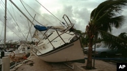 In this Aug. 24, 1992 photo, a sailboat sits on a sidewalk at Dinner Key in Miami after it was washed ashore by Hurricane Andrew.