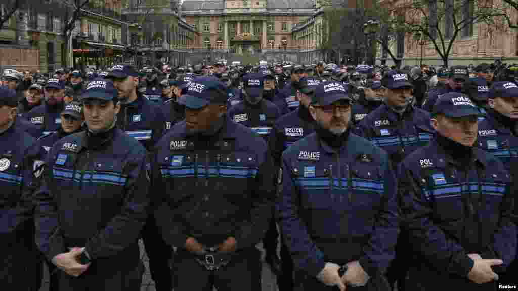 French municipal police officers react as they attend a national tribute for the three officers killed during last week's terrorist attacks, in front of Paris Prefecture, Jan. 13, 2015. 