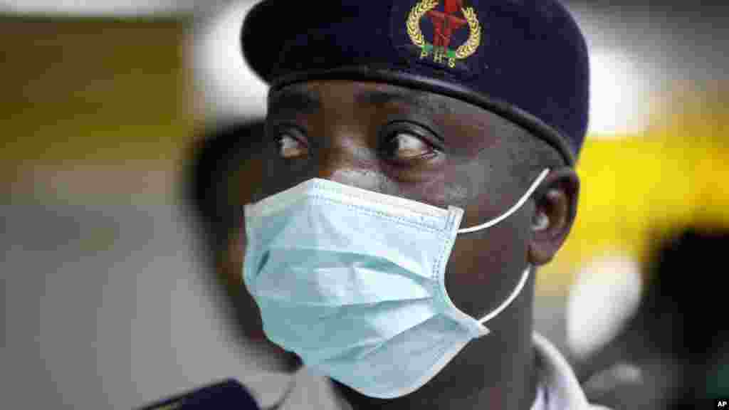 A Nigerian health official wearing a protective mask waits to screen passengers at the arrivals hall of Murtala Muhammed International Airport in Lagos.