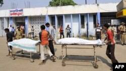 Volunteers and hospital staff transport the bodies of killed Indian Central Reserve Police Force personnel at a hospital in Gaya, October 18, 2012.