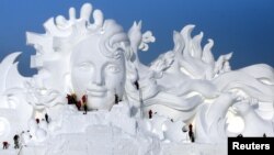 FILE - Artists work on snow sculptures at an exhibition in Harbin, Heilongjiang province, China, Dec. 13, 2016.