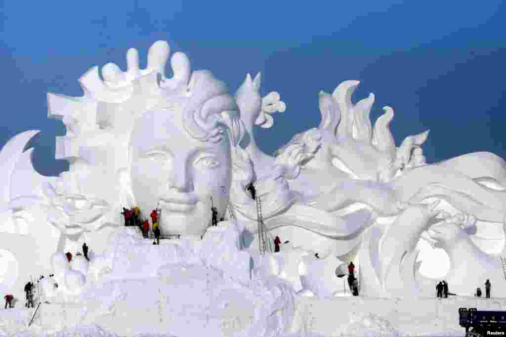 哈尔滨国际冰雪节的雪雕，人们正在加工（2016年12月13日）