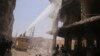 Civil defence members try to put out a fire after what activists claim was a car explosion in a market in central Douma in the eastern al-Ghouta, near Damascus June 28, 2014