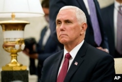 Vice President Mike Pence listens to a reporter's question during a meeting with President Donald Trump and Iraqi Prime Minister Mustafa al-Kadhimi in the Oval Office of the White House, Aug. 20, 2020.