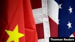 FILE - The flags of the US and China are displayed at American International Chamber of Commerce (AICC)'s booth during China International Fair for Trade in Services in Beijing, China, May 28, 2019.