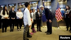 U.S. Secretary of State John Kerry (3rd R) chats with one of Chinese teacher Peng Ye (4th R)'s four students during an issuance ceremony to be the first Chinese citizens to receive ten-year U.S. visas from Kerry at the U.S. embassy, in Beijing, November 1