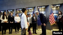 Ngoại trưởng Hoa Kỳ John Kerry (thứ ba từ phải sang) trò chuyện với một trong bốn em học sinh trong buổi lễ trở thành những công dân Trung Quốc đầu tiên được cấp visa Mỹ 10 năm tại đại sứ quán Hoa Kỳ ở Bắc Kinh, 12/11/2014.