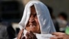 FILE - A woman mourns as she looks for her relatives at the site of a suicide attack in Kabul, Afghanistan, Nov. 27, 2014. 