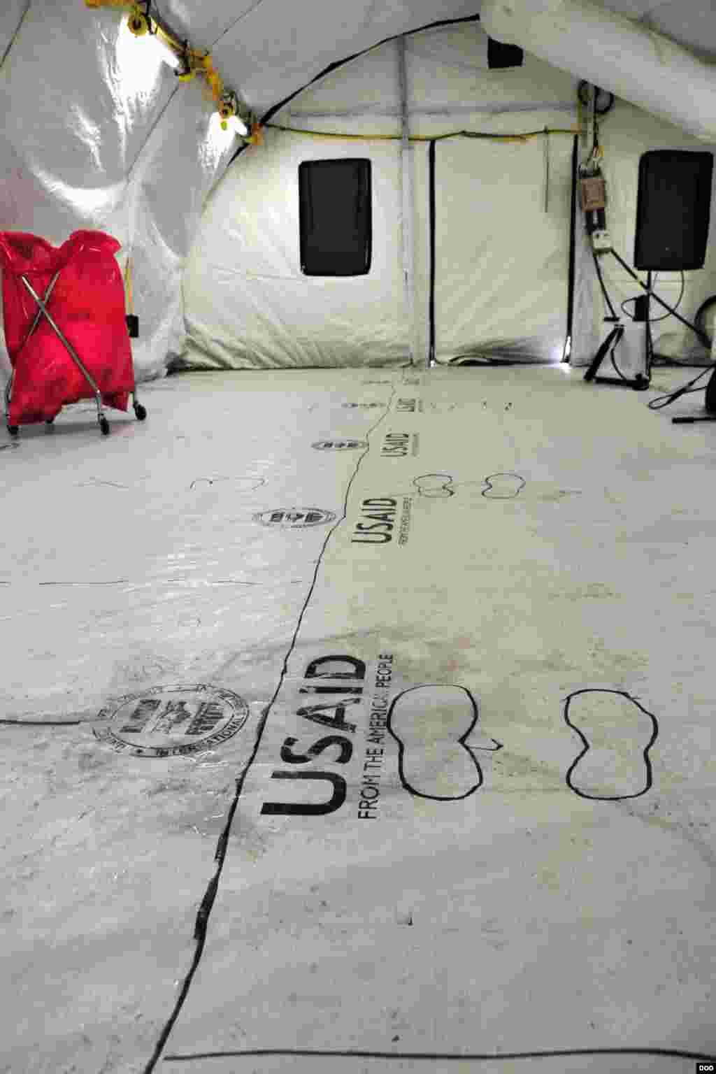 Footprint outlines mark the floor in the doffing station where medical workers at the Monrovia Medical Unit will decontaminate and take off their personal protective equipment after working in the high-risk Ebola zone, near Monrovia, Liberia, Nov. 4, 2014. (Sgt. 1st Class Nathan Hoskins/DOD)