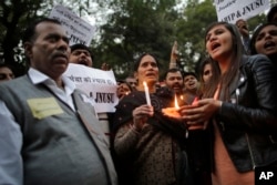 FILE - The father, left and mother, center, of the Indian student victim who was fatally gang raped on this day three years ago on a moving bus in the Indian capital, join others at a candle lit vigil in New Delhi, India, Dec. 16, 2015.