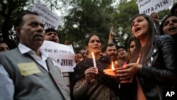 The father, left and mother, center, of the Indian student victim who was fatally gang raped on this day three years ago on a moving bus in the Indian capital, join others at a candle lit vigil in New Delhi, India, Dec. 16, 2015. 