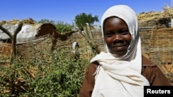 Khadieja Omer Mohamed, a 4th grader at Sudan Aid School at Dereige camp for the internally displaced poses for a photograph in Nyala in South Darfur, Sudan, Nov. 19, 2015. 