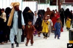 FILE - Internally displaced tribal people return to their villages cleared by the Pakistani army, in Bannu, Pakistan, March 31, 2015.