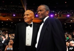FILE - Harry Belafonte, left, and Sidney Poitier pose in the audience at the 43rd NAACP Image Awards, in Los Angeles, Feb. 17, 2012.