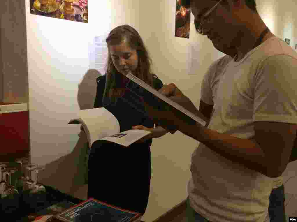 Visitors skim through the ‘Vanishing Act’ at the book launch Thursday.