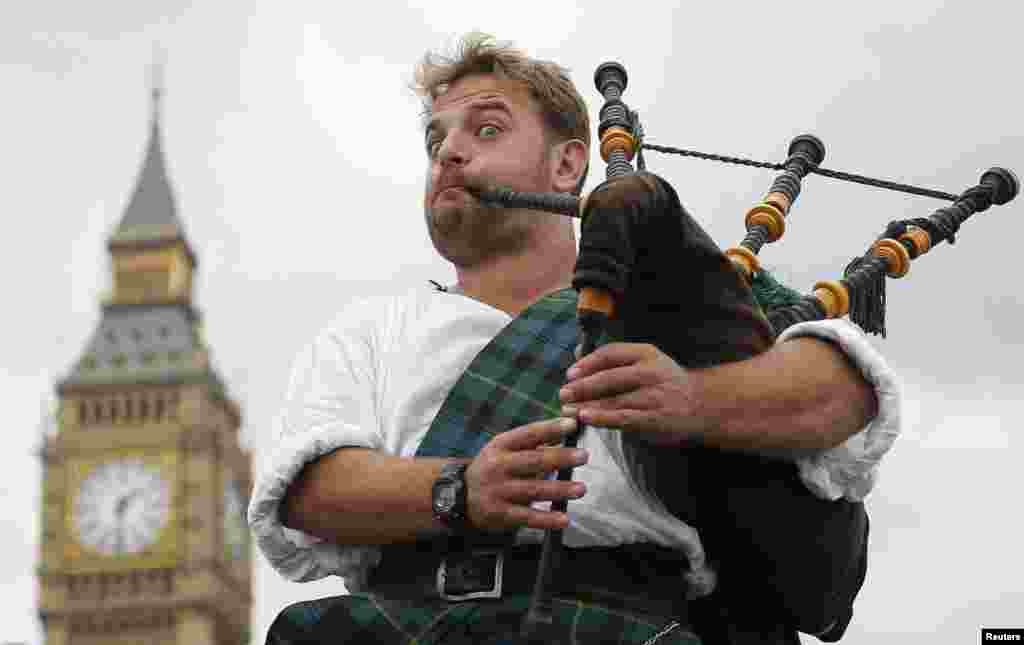 Pemusik jalanan, David Whitney dari Aberdeen, Skotlandia, ngamen di dekat Big Ben di London.