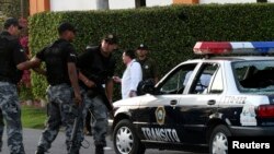 Agentes de la policía junto a una patrulla, en la que dos agentes de tránsito fueron abatidos a tiros, en Navolato, a unos 25 km al oeste de Culiacán en el estado mexicano de Sinaloa. [Foto de archivo]