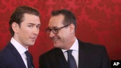 Newly sworn-in Austrian Chancellor Sebastian Kurz, left, and new Vice Chancellor Heinz-Christian Strache talk during the swearing-in ceremony of the new Austrian government led by a conservative and a nationalist party in Vienna, Austria, Monday, Dec. 18,