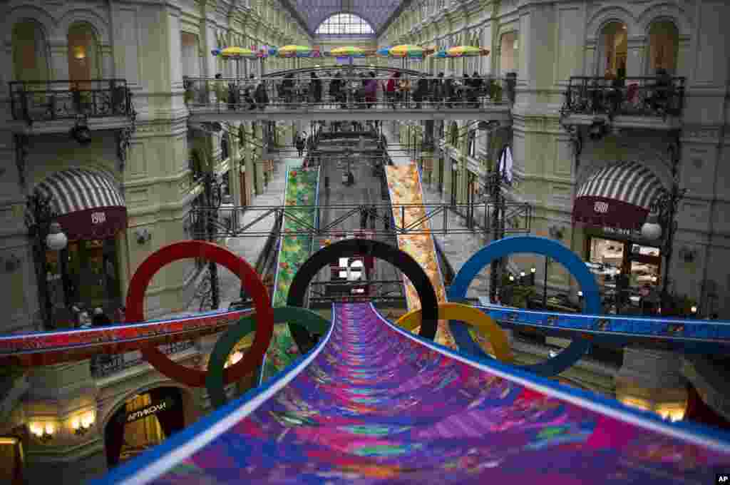 Visitors walk inside the GUM department store decorated with Olympic rings in Moscow, Russia, Feb. 12, 2014. 