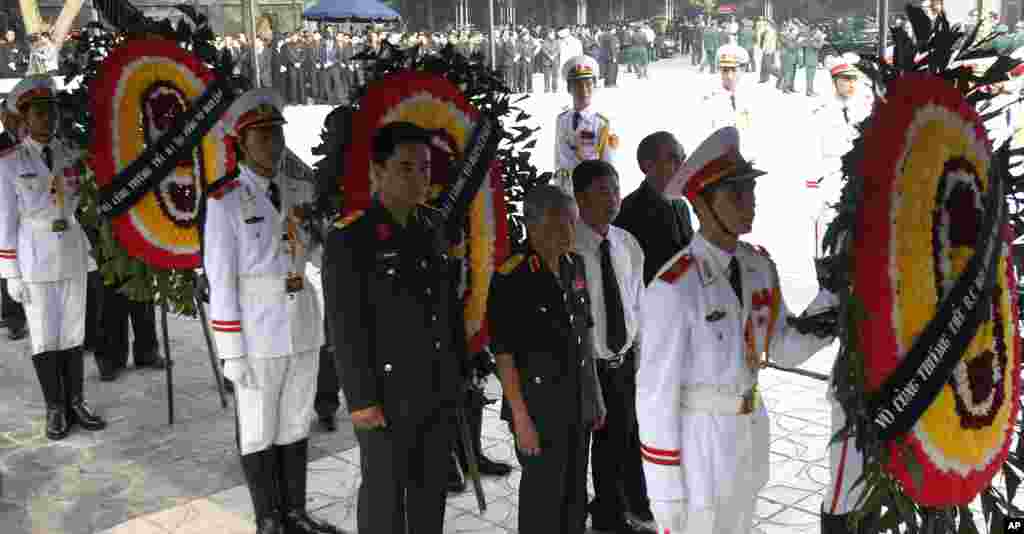 Cựu Tổng Bí thư Ðảng Cộng sản Việt Nam Lê Khả Phiêu (đứng giữa hai vòng hoa) viếng Ðại tướng Võ Nguyên Giáp tại Nhà tang lễ Quốc gia ở Hà Nội, ngày 12/10/2013.
