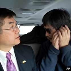 In this photo released by the US Embassy Beijing Press Office, blind lawyer Chen Guangcheng makes a phone call as he is accompanied by U.S. Ambassador Gary Locke on the way to a hospital in Beijing, May 2, 2012.