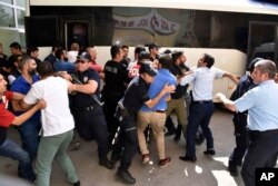 Police officers try to stop people attacking a judge believed to be member of a coup plotter group in Erzurum, Turkey, July 19, 2016.