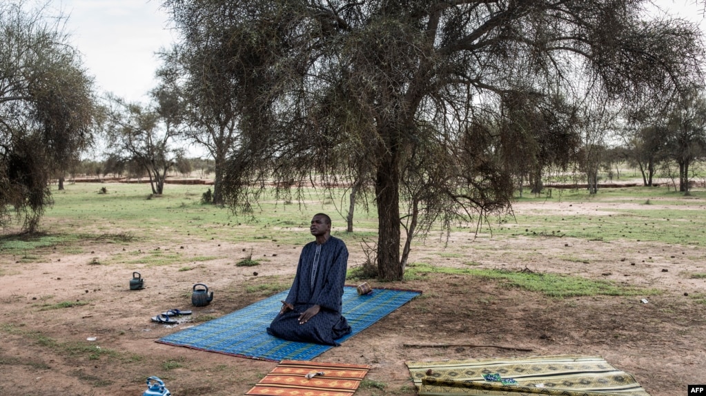 Un pasteur peul fait sa prière du soir avant de partir pour trouver un camp pour la nuit à Barkedji le 20 juillet 2020, ils sont sur la route depuis deux semaines, en direction du nord vers la frontière mauritanienne.