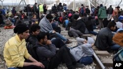 Des réfugiés afghans sont assis sur le chemin de fer qui relie la Grèce avec la Macédoine, 22 février 2016.