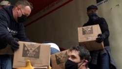 Volunteers unload boxes of food from a truck for a distribution program run through Mosaic West Queens Church in the Sunnyside neighborhood of the Queens borough of New York on Monday, Feb. 22, 2021. (AP Photo/Emily Leshner)