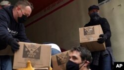 Volunteers unload boxes of food from a truck for a distribution program run through Mosaic West Queens Church in the Sunnyside neighborhood of the Queens borough of New York on Monday, Feb. 22, 2021. (AP Photo/Emily Leshner)