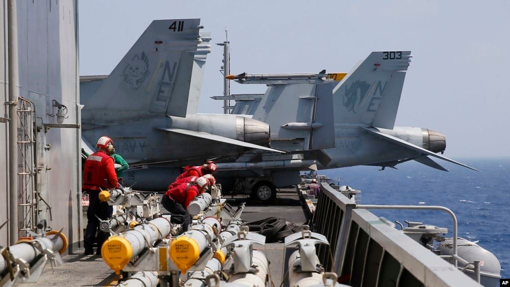 2017年3月3日在南中国海例行巡航前，美国航母卡尔·文森号上的海军人员准备为F-18战斗机加装导弹。(photo:VOA)