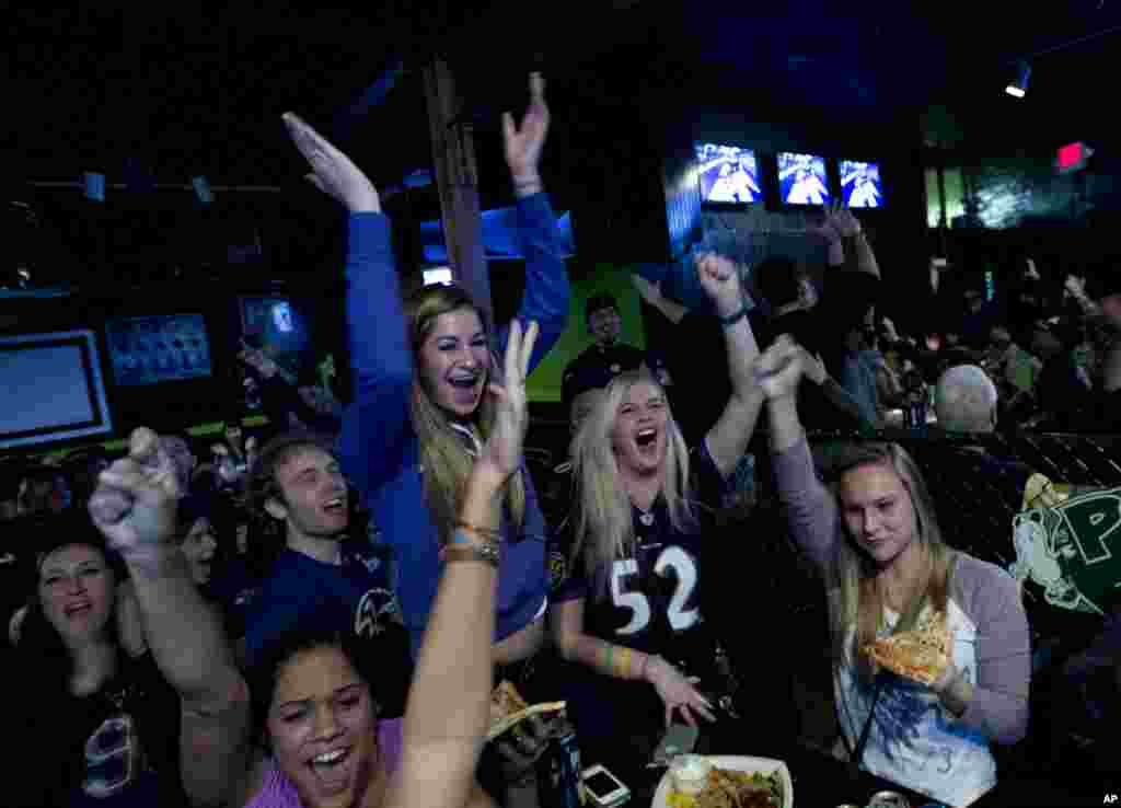 Baltimore Ravens fans cheers for their team after they scored the first touchdown against Sand Francisco 49ers, as they watch the game at local pub in Baltimore Md. on Sunday Feb. 3, 2013.