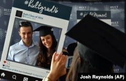 Hult International Business School graduate Victoria Stanciu and her fiance pose as her classmate takes a photo after the graduation ceremony in Boston