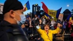 A woman shouts during an anti-government and anti-restrictions protest organized by the far-right Alliance for the Unity of Romanians, in Bucharest, Oct. 2, 2021. Thousands took to the streets calling for the government's resignation, as Romania reported 12.590 new COVID-19 infections in the past 24 hours.
