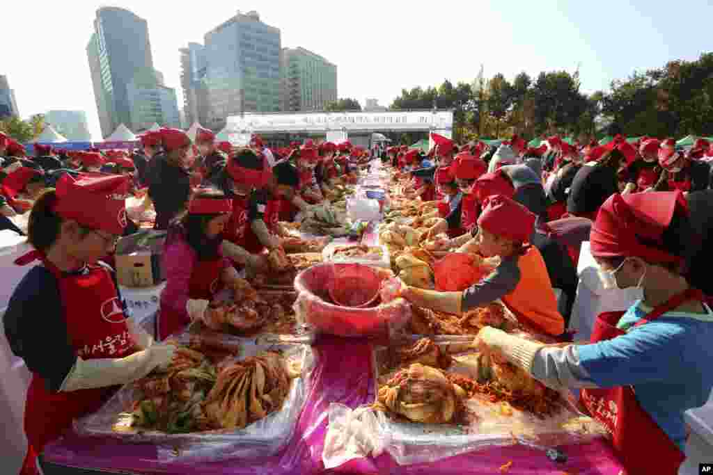 Para peserta membuat kimchi, hidangan tradisional Korea yang terbuat dari sayuran yang difermentasi, untuk memecahkan rekor dunia Guinness dengan jumlah terbesar orang yang membuat kimchi di satu tempat selama Festival Kimchi di Seoul Plaza, Seoul, Korea Selatan.