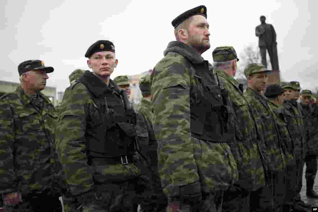 Members of the Crimean self-defense forces gather for their morning briefing prior to patrolling the city near a statue of Vladimir Lenin in Simferopol, Crimea, March 27, 2014.&nbsp;
