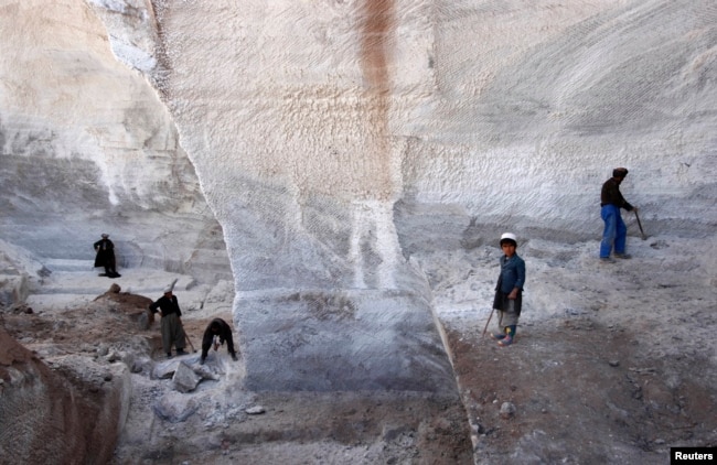 FILE - Men work at Taqcha Khana salt mine in Namak Aab district of Takhar province northeast of Kabul, March 10, 2009.