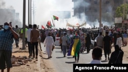 Opponents of the military coup wave national flags as they take part in a protest in the Khartoum North, Sudan, Nov. 13, 2021.