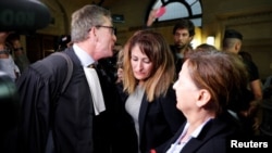 Nathalie Haddadi (C), whose radicalised son fought in Syria where he allegedly died as a jihadist, and her lawyer Herve Denis leave the criminal court in Paris, France, Sept. 28, 2017.