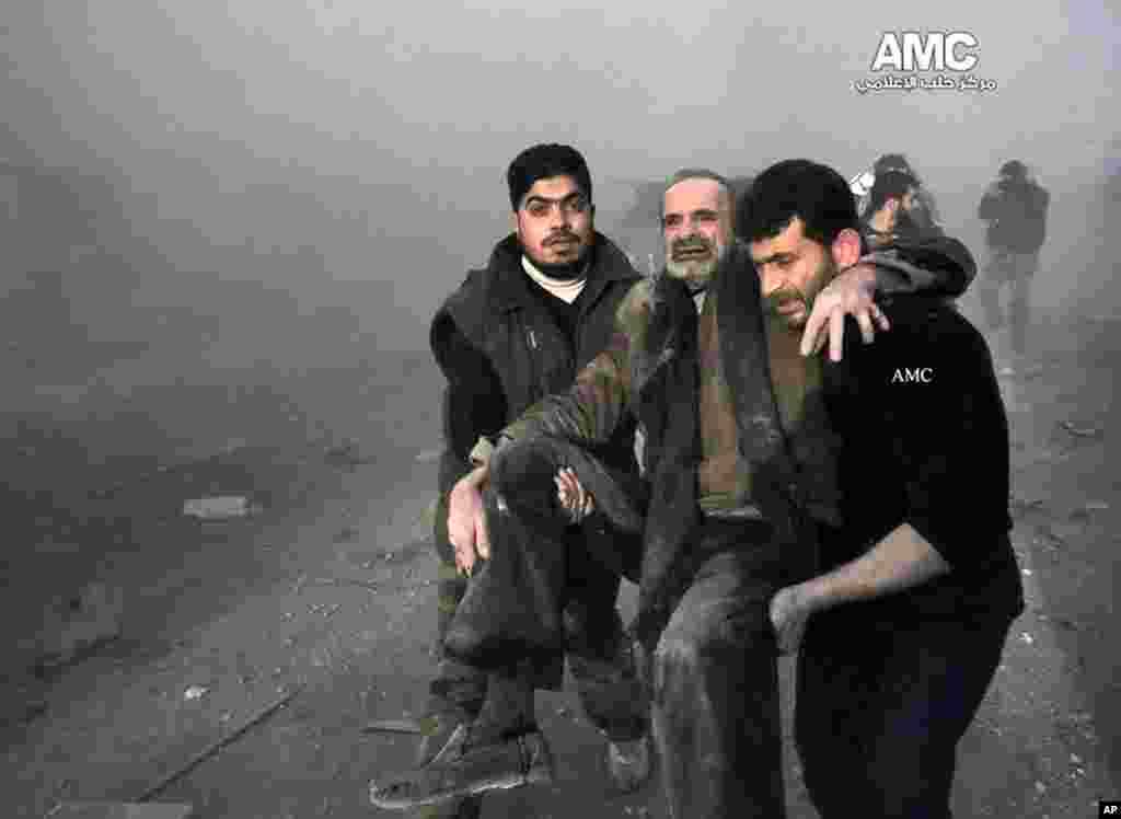 This citizen journalism image provided by Aleppo Media Center shows Syrian men helping a wounded man after a government airstrike in Aleppo, Jan. 29, 2014.