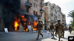 Tentara Lebanon berupaya mengamankan kawasan di depan Credit Libanais Bank yang dibakar oleh pengunjuk rasa anti-pemerintah, di kota utara Tripoli, Lebanon, Selasa, 28 April 2020. (Foto: dok).
