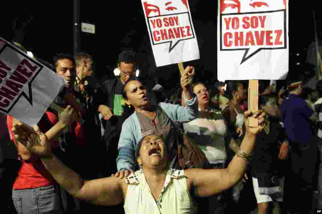 A supporter of Venezuelan President Hugo Chavez cries as she holds a sign that reads in Spanish &quot;I am Chavez,&quot; in Bolivar square, Caracas, Venezuela, March 5, 2013. 